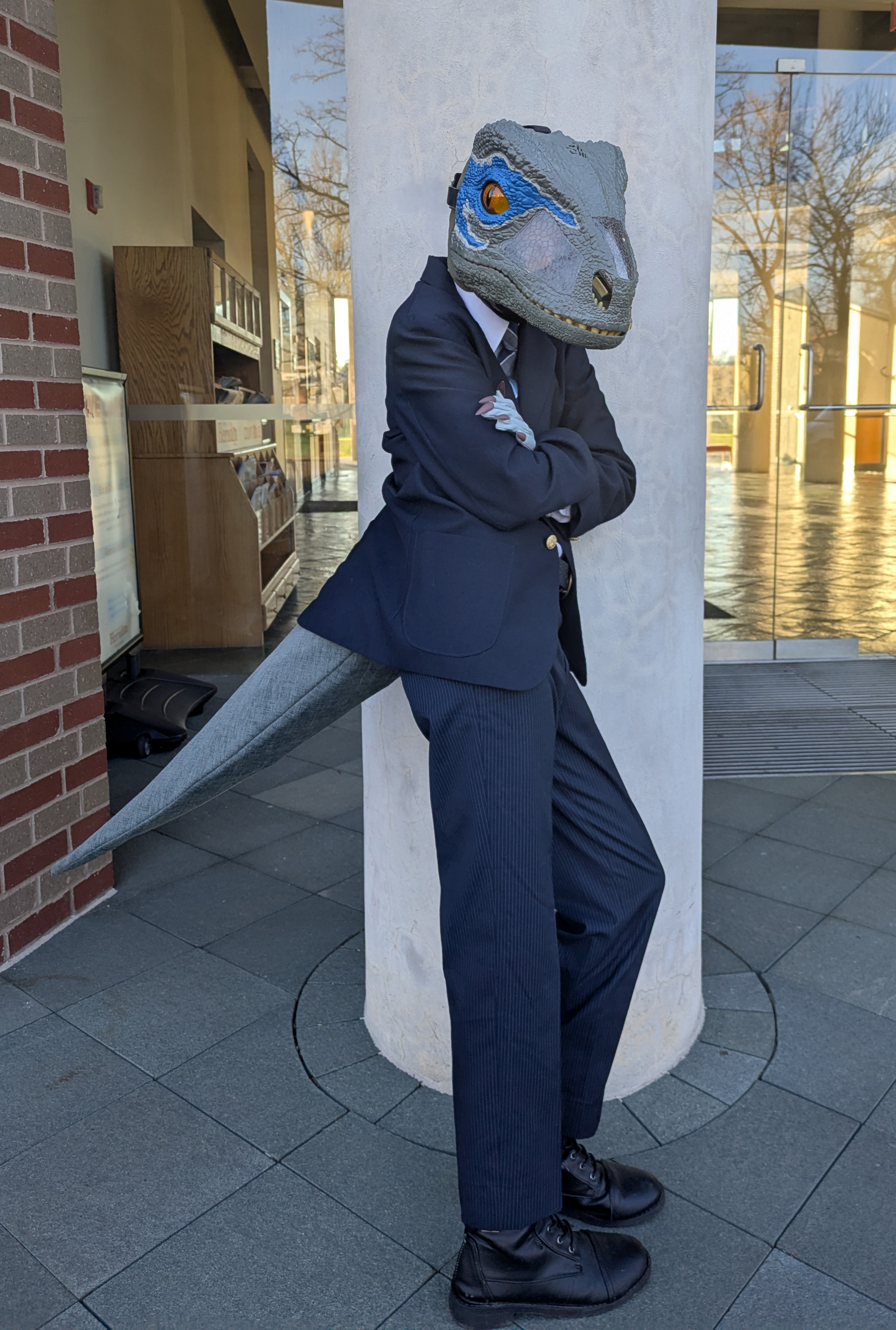 Serious dinosaur lawyer leaning on a pillar.